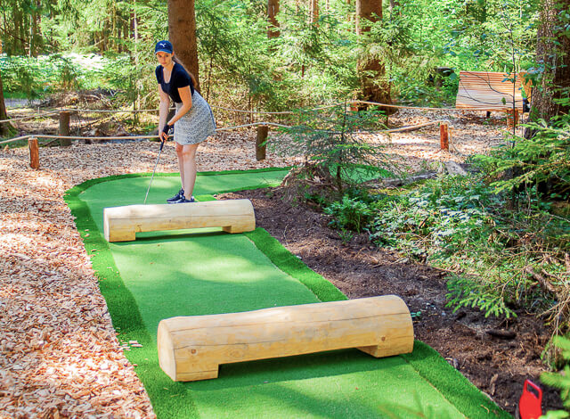 Junge Frau spielt Adventure Golf